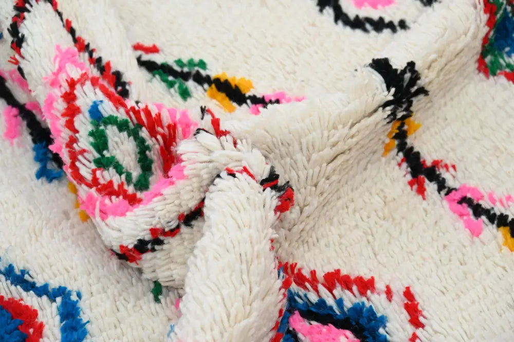 A decorbites™ handmade moroccan azilal rug in off-white natural wool with vibrant geometric patterns in multiple colors