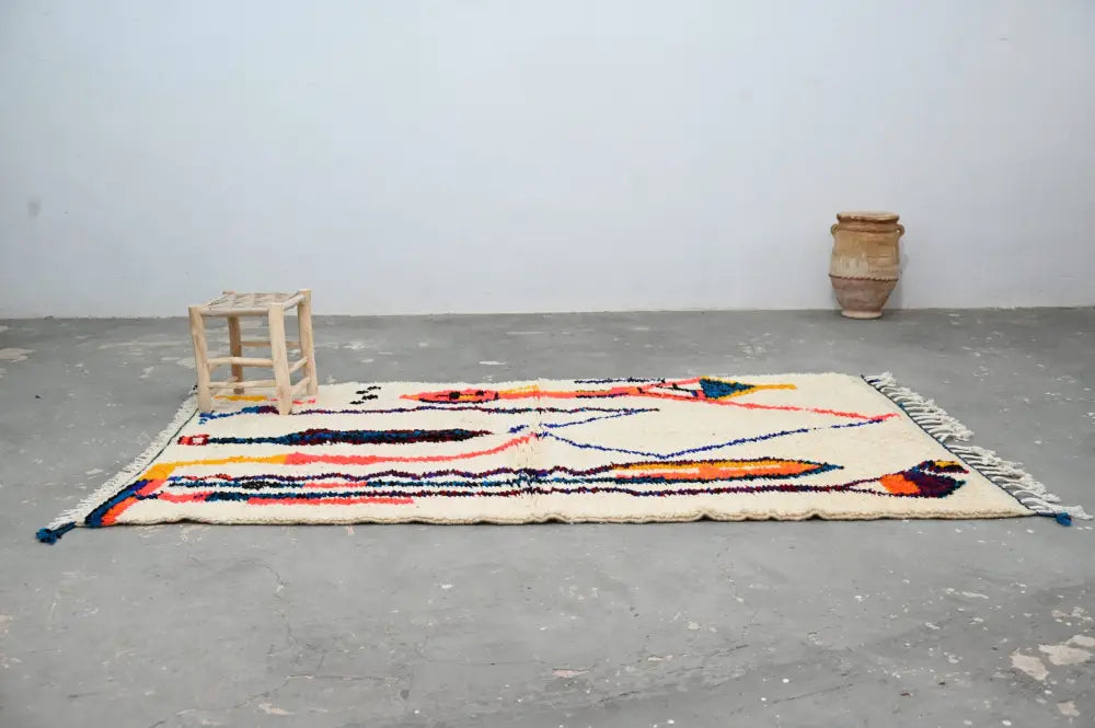 Decorbites™ handmade traditional azilal rug in cream with bold orange, blue, and black geometric patterns and fringed edges