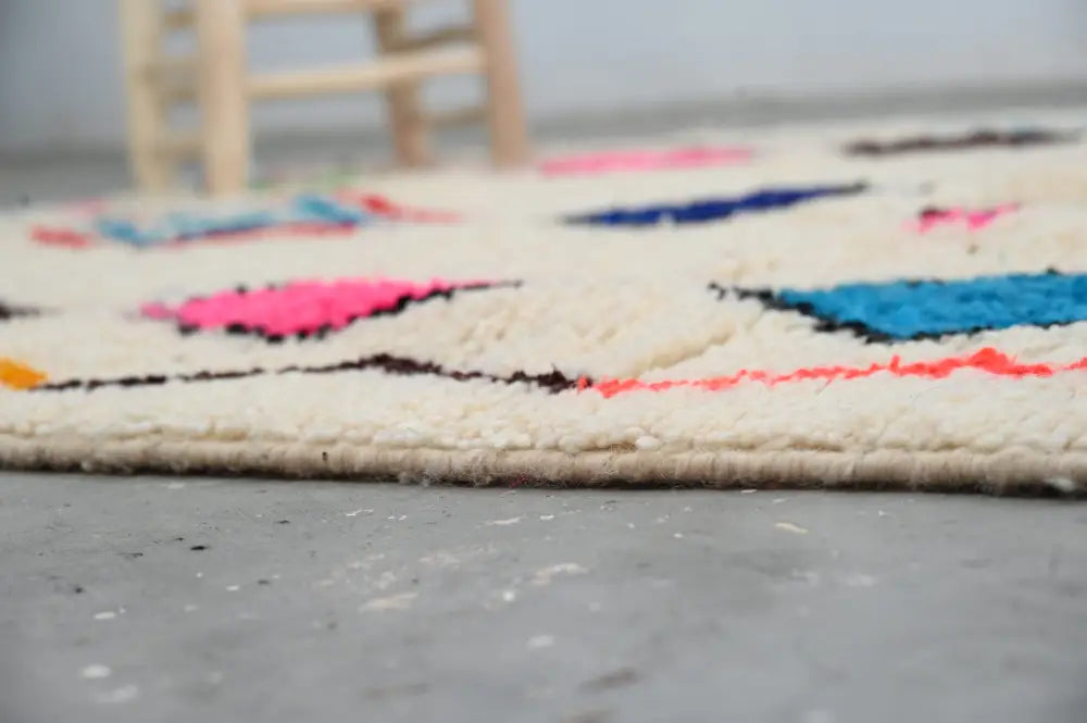 Cream-colored decorbites™ handmade azilal rug 250x160cm with bold pink blue orange and black geometric patterns in natural wool