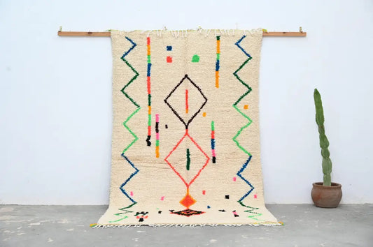 Beige moroccan azilal rug with colorful geometric patterns in red green blue orange made of natural wool 253x150 cm
