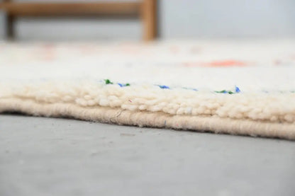 Cream-colored handmade moroccan azilal rug with textured fringed edge and subtle blue and green accents 285x220 cm