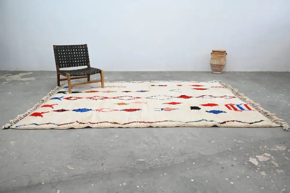 Cream-colored handmade moroccan azilal rug with vibrant red blue and black geometric patterns and fringed edges 285x220 cm