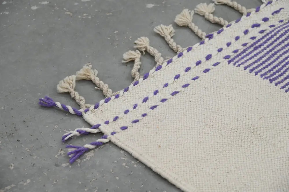 Cream-colored moroccan handmade azilal rug with natural wool and purple white braided fringe 291x182 cm