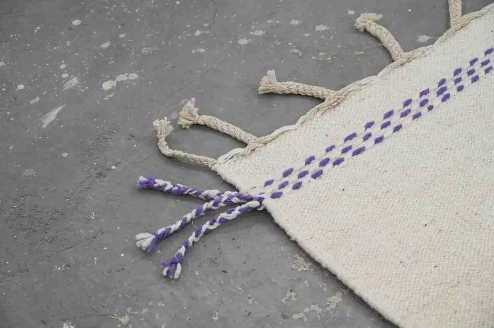 Cream-colored decorbites™ handmade moroccan azilal rug with purple stitched dots and braided tassels 300x203 cm