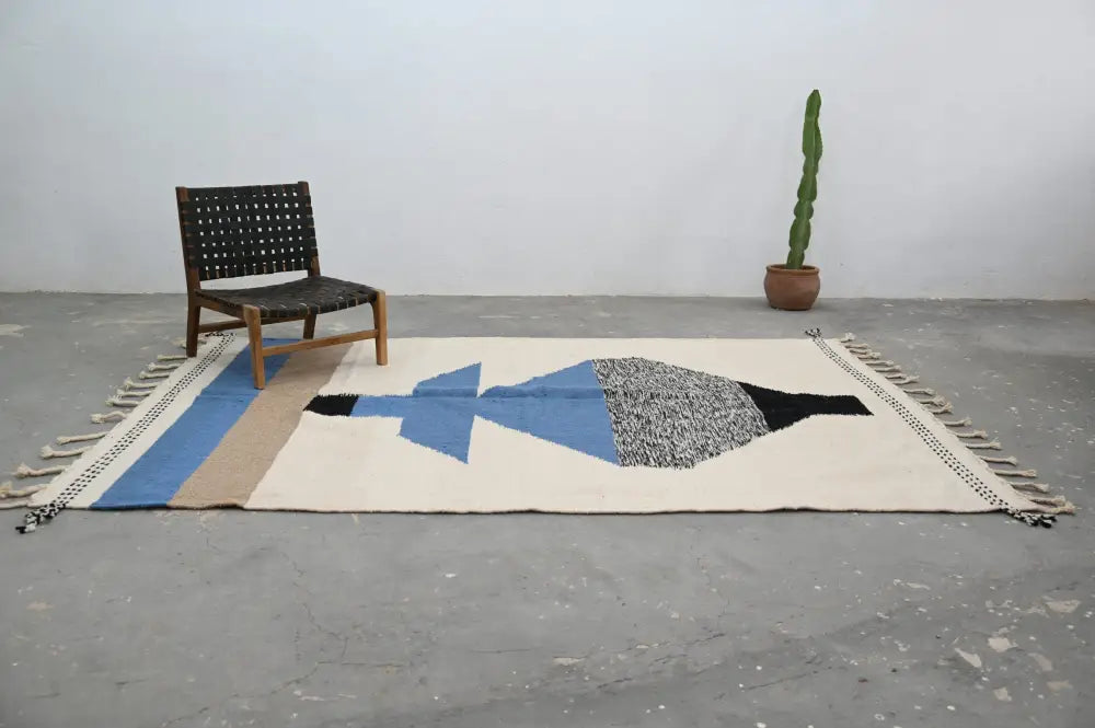 Beige wool handmade traditional azilal rug with blue black gray geometric design and fringe edge moroccan craftsmanship