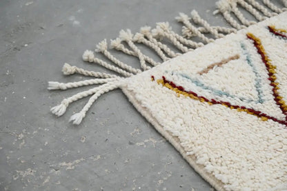 Cream-colored handmade moroccan azilal rug with geometric patterns in earthy tones and white fringe 305x206cm
