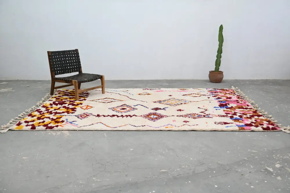 Beige handmade moroccan azilal rug with colorful geometric and floral patterns and fringed edges 309x207cm