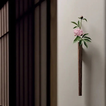 DecorBites™ handmade nordic wall vase in dark solid wood holding a pink peony with green leaves