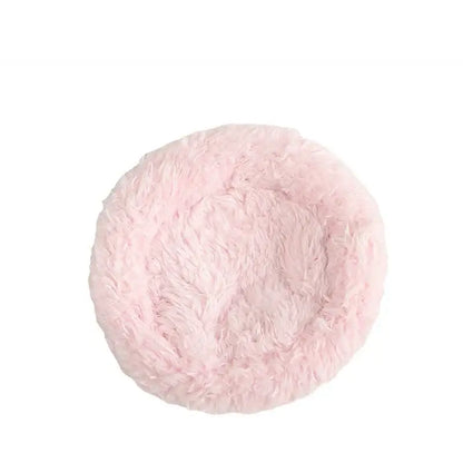 Pink fluffy pet bed with soft plush texture placed inside a handwoven grass bird cage hut for small birds