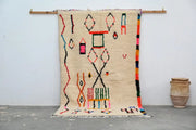 Beige handwoven moroccan azilal rug with colorful red green pink and black geometric patterns 245x146 cm by DecorBites