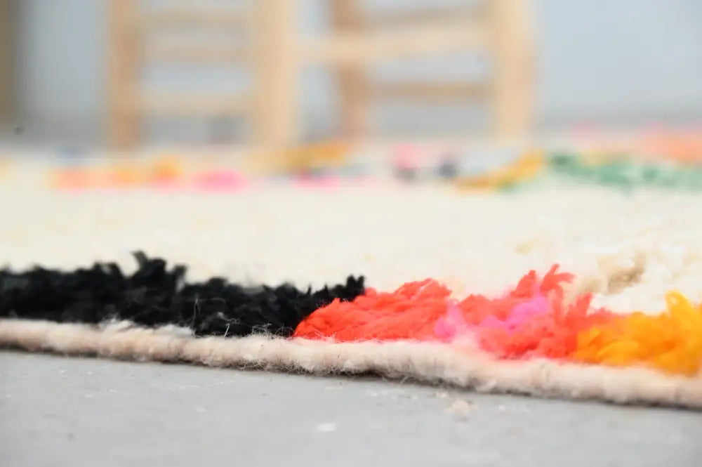 DecorBites™ handwoven Moroccan azilal rug featuring vibrant black orange pink and yellow colors with textured fringe 245x146 cm