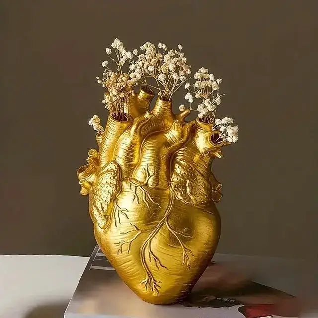 Golden heart shape resin vase by decorbites holding delicate white babys breath flowers in anatomically detailed design