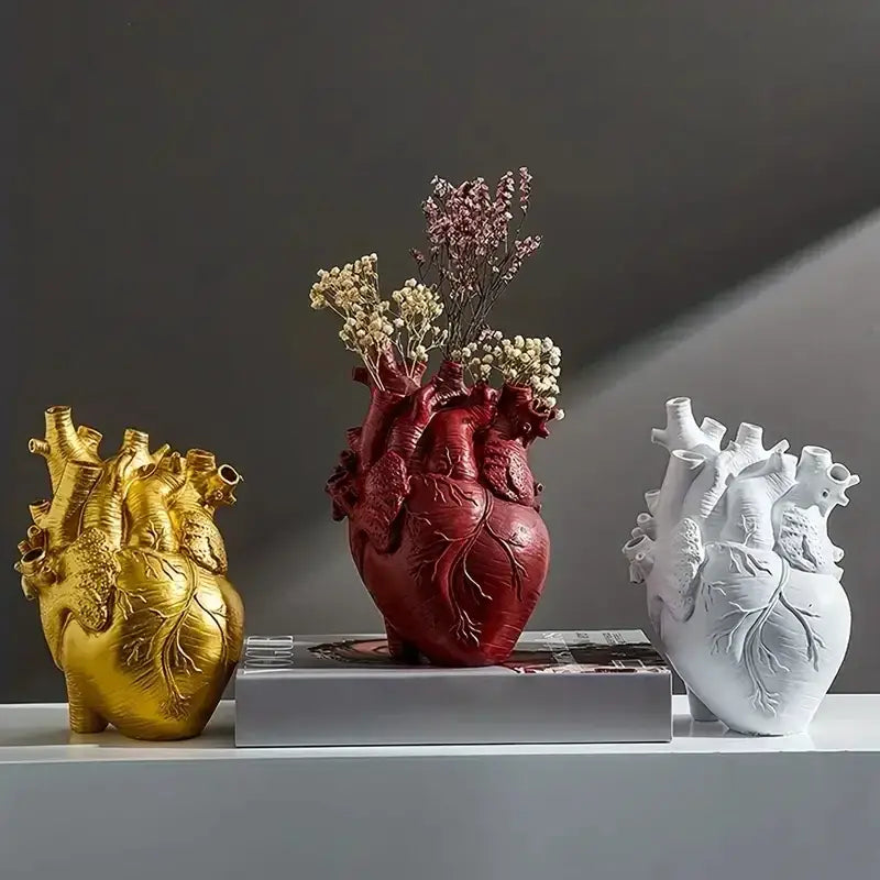 Red anatomically detailed heart shape resin vase by decorbites holding dried flowers in a decorative display