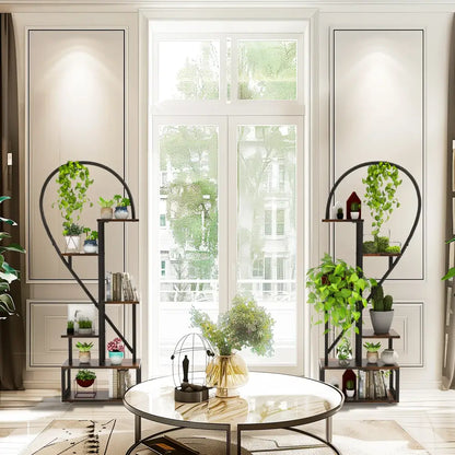 Black metal heart shaped plant stand by DecorBites with 6 tiers holding potted plants and decorative items