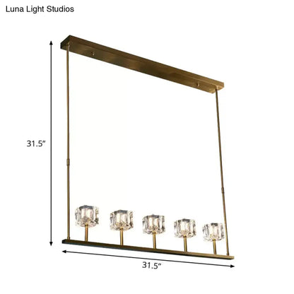 Gold-toned rectangular pendant light fixture with five faceted crystal glass shades and bulb base for dining room use