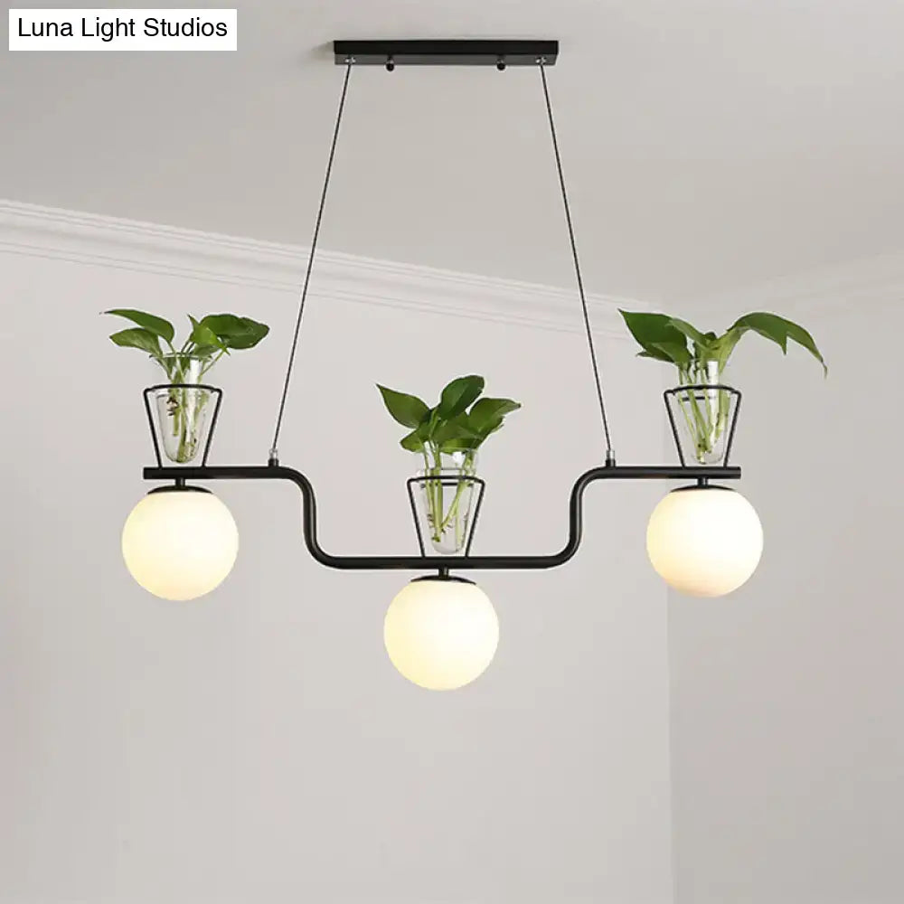Decorbites industrial black island light fixture with three opal glass globe pendants and clear glass pots with plants