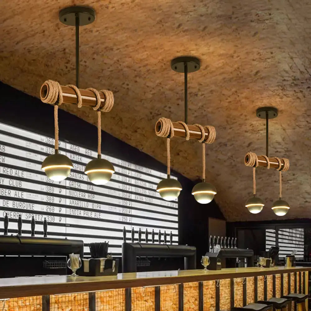 Decorbites industrial linear chandelier with black iron pendant, bamboo tubes wrapped in rope, and brass globe bulbs