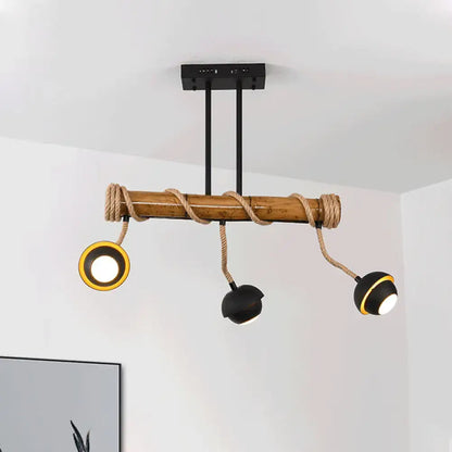 Rustic bamboo ceiling light fixture with black metal arms and rope accents in industrial linear island chandelier design