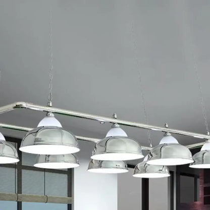 Chrome-finished dome-shaped metal mirrored bowl pendant lights with white shades suspended from a sleek metal bar