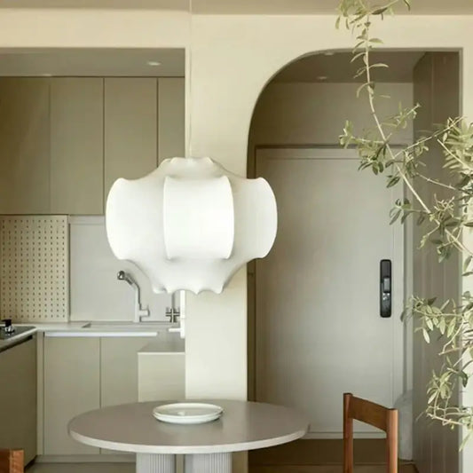White decorbites italian silk pendant light with layered organic design hanging above round dining table