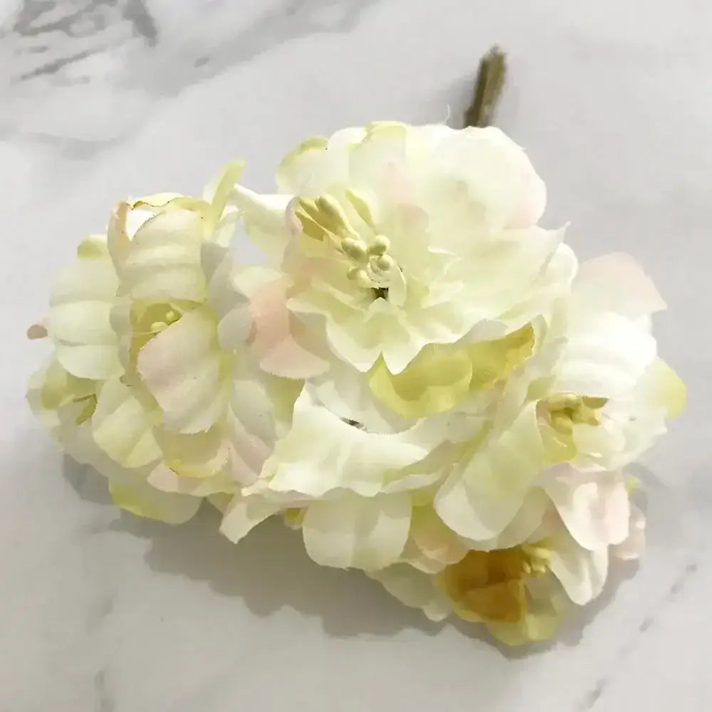 A cluster of decorbites ivory flower cherry stamen berries with pale cream and soft yellow layered petals for wedding decor