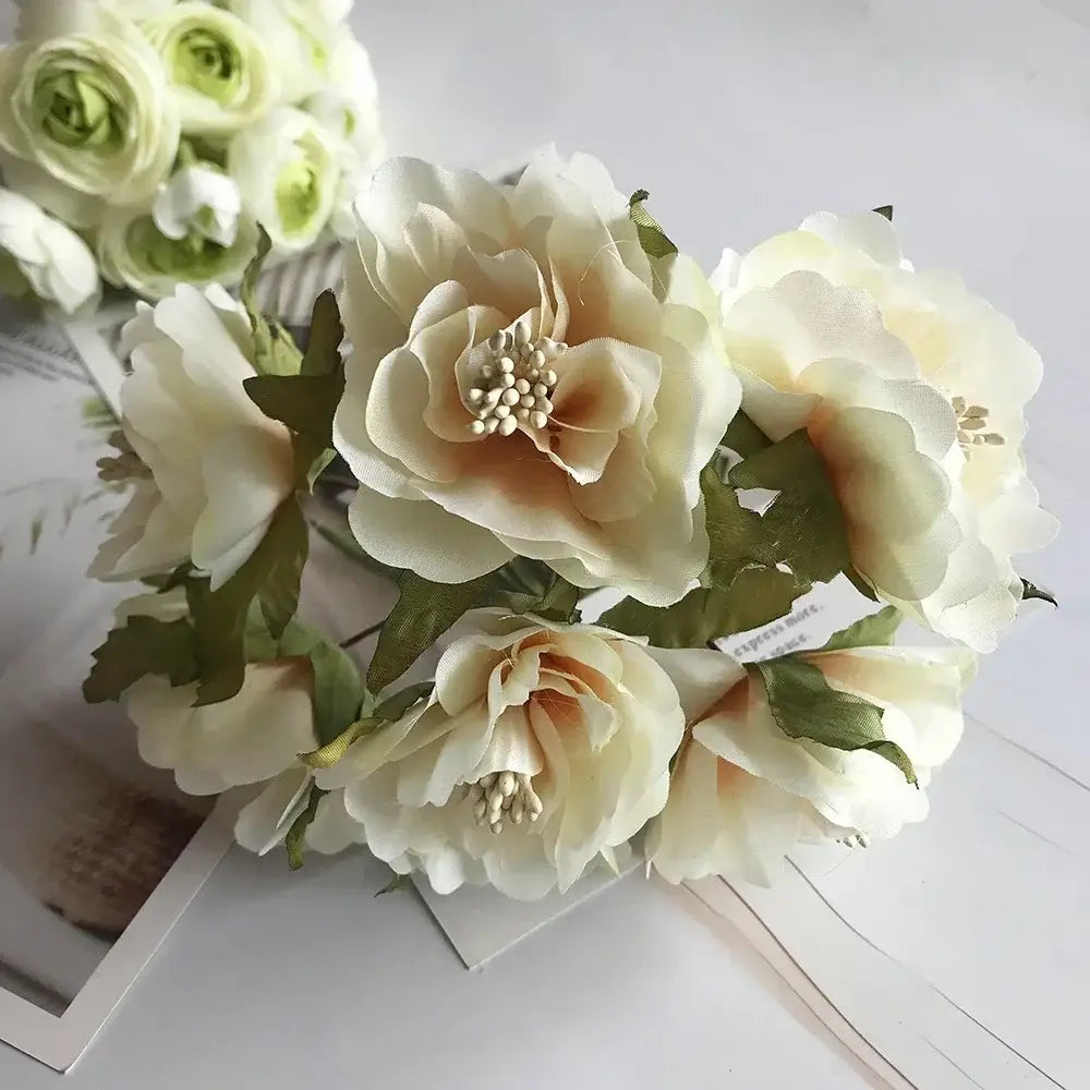 A delicate decorbites ivory flower cherry bouquet with cream and pale peach artificial peonies and green fabric leaves