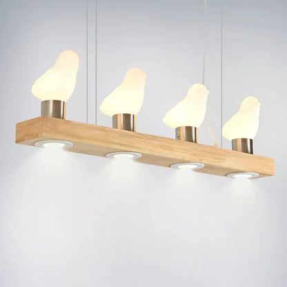 Modern wooden pendant light with four glowing ivory glass bird lamps and brushed brass bases from decorbites glass bird island collection