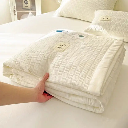 A neatly folded white decorbites jacquard summer cool blanket with subtle woven texture and soft plush appearance