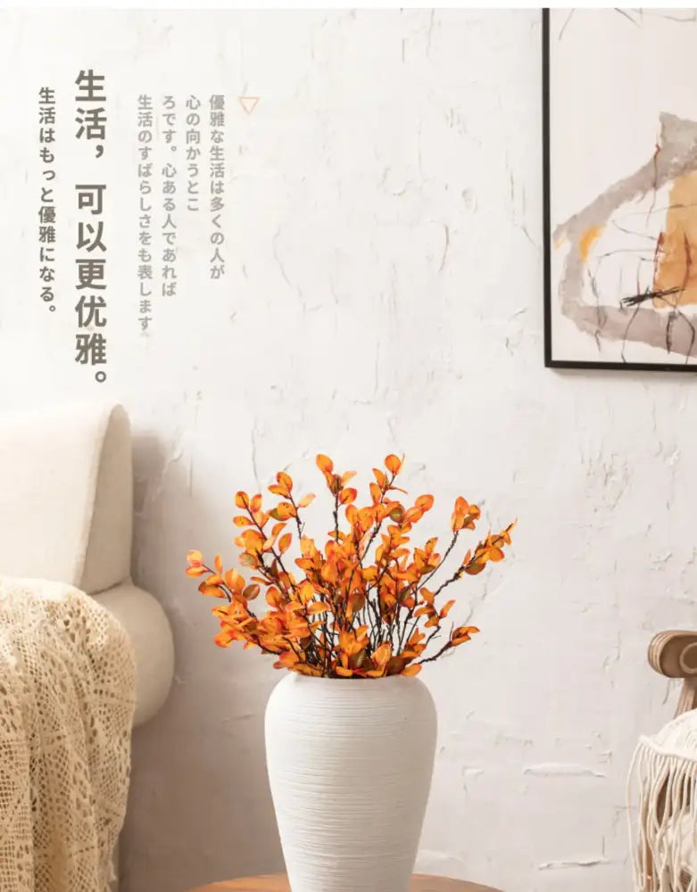White ceramic minimalist hydroponic vase with textured surface holding orange artificial foliage by DecorBites™