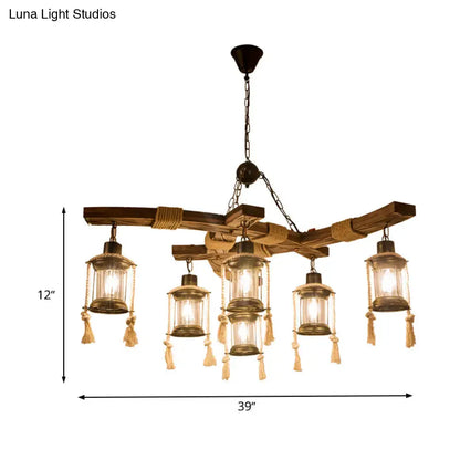 Rustic wooden chandelier with five lantern-style clear glass lights and brass metal frame with beige tassels for led incandescent use
