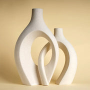 Two minimalist white ceramic vases with smooth curves and open circular cutouts large 21cm ceramic vase for home decor