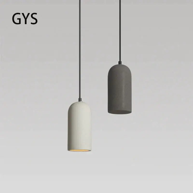 Two minimalist pendant lights with cylindrical white and gray concrete shades from DecorBites LED cement chandelier