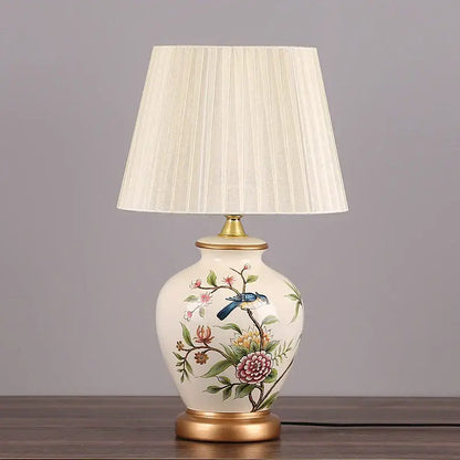 Cream-colored decorbites led ceramic table lamp with hand-painted floral bird design and gold-toned metal accents