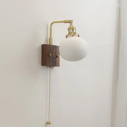 DecorBites led ceramic wall sconce with brass finish, dark wood base, and opaque white glass shade light fixture