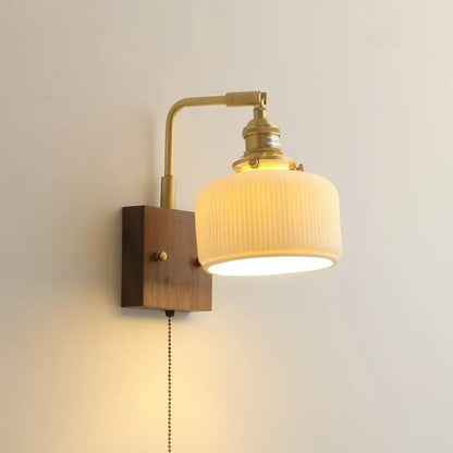 Brass-finished decorbites led ceramic wall sconce with ribbed off-white glass shade and wooden mounting plate light fixture