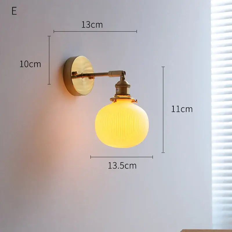 Vintage-style brass decorbites led ceramic wall sconce with warm ribbed yellow glass globe for bedroom lighting
