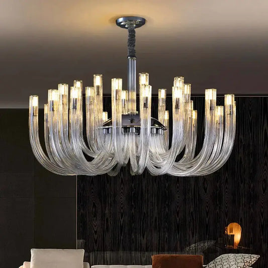 A modern decorbites led chandelier with curved transparent glass arms and a chrome lighting fixture for bedroom use