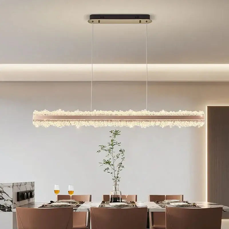 A decorbites led chandelier with a rose gold frame and cascading crystals, suspended from a black ceiling mount