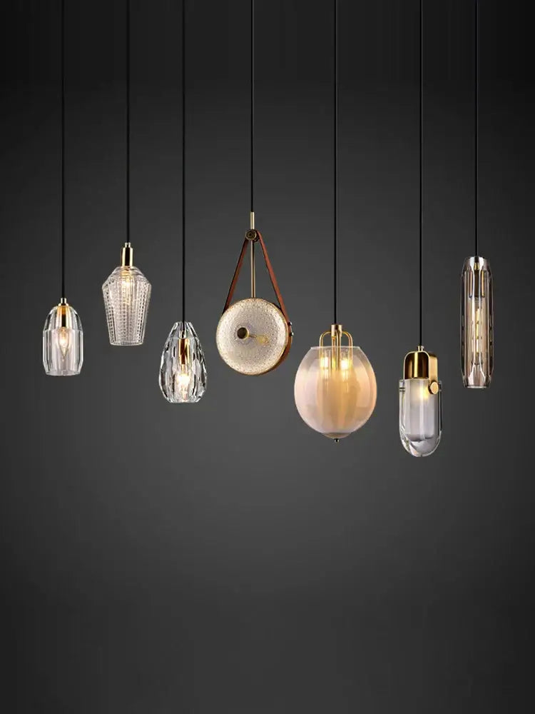 A collection of decorbites led chandelier lighting with clear glass shades gold metal accents and black cords for dining room
