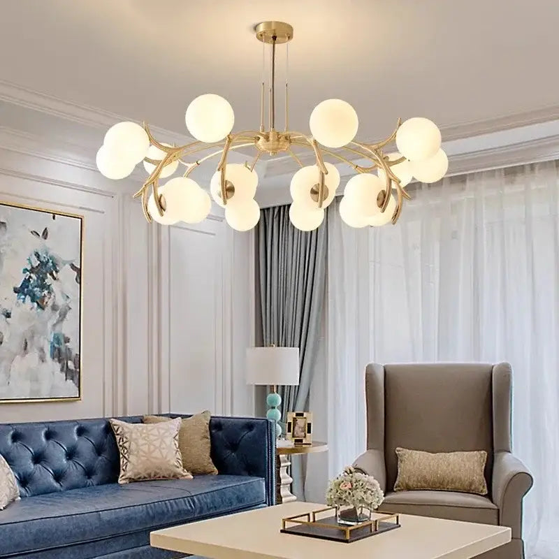 Gold-toned decorbites led chandelier lighting with frosted glass globe lights in a branching tree-like design for living spaces