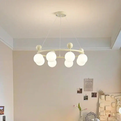 Off-white circular DecorBites led chandelier with multiple frosted glass globe bulbs suspended by thin cords for indoor lighting
