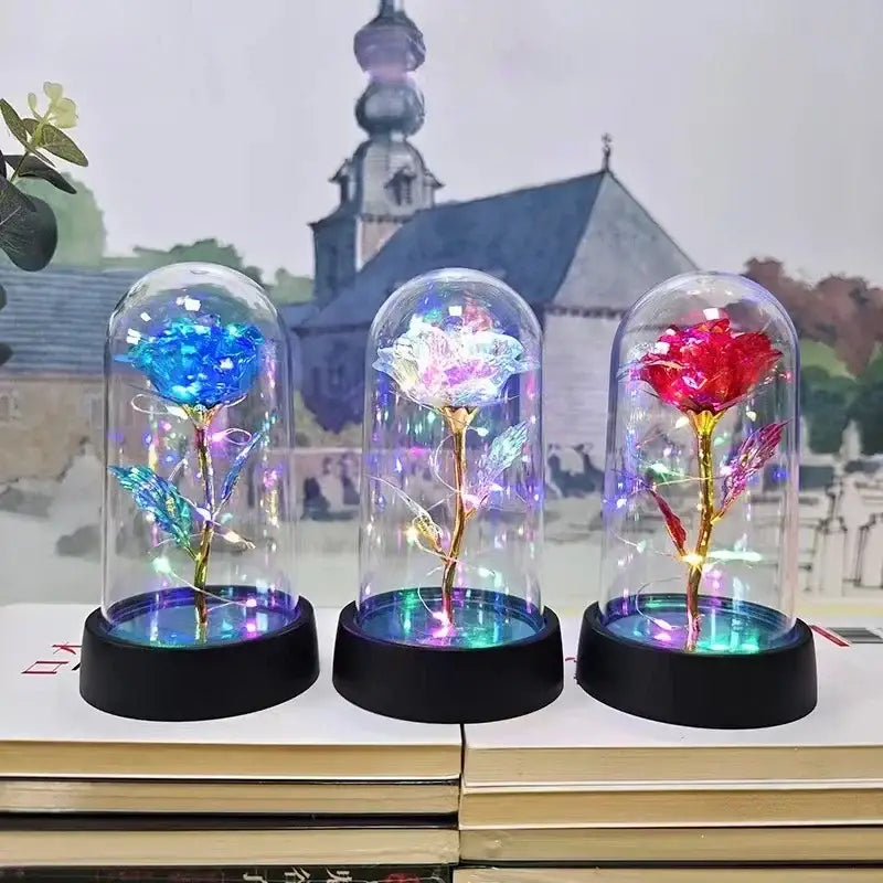 Three decorbites™ eternal rose light LED roses in glass domes with gold stems and colorful petals on black bases