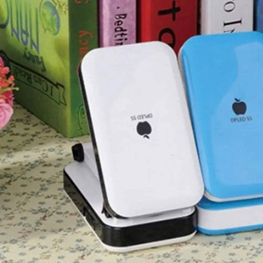 White and black portable phone charger with minimalist apple logo alongside decorbites led folding desk lamp for student use