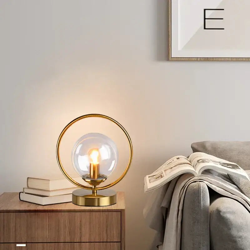 Modern brass decorbites led glass table lamp with clear globe and brass ring emitting warm light for stylish living rooms