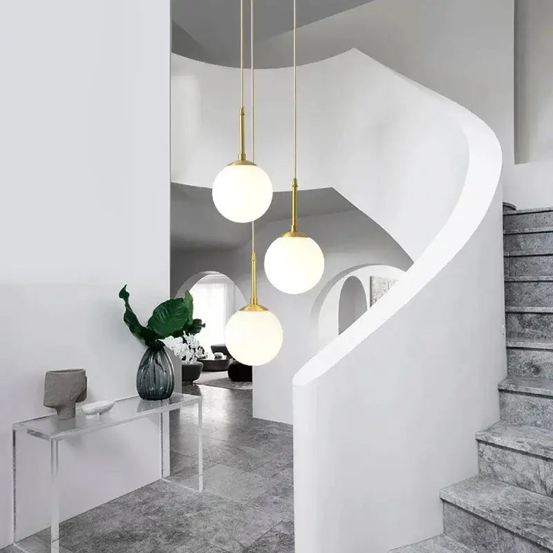 Three gold-finished spherical pendant lights with frosted glass globes in decorbites led glass ball chandelier