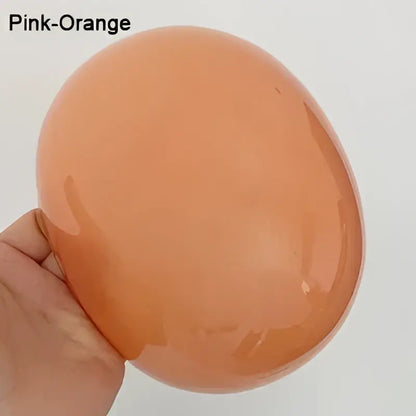 A smooth glossy pink-orange glass ball held in hand from decorbites led glass balls pendant lights collection