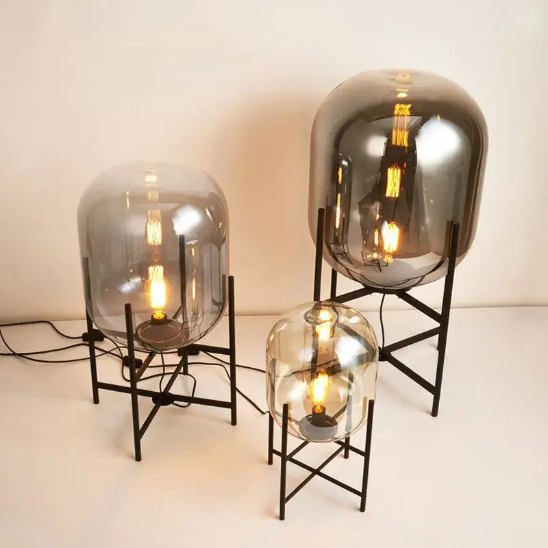 Three modern decorbites led glass floor lamps with frosted globes and black metal stands in minimalist design