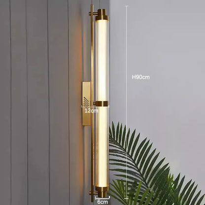 Gold-toned decorbites led glass wall lamp with cylindrical glass tube and brushed metal in minimalist design for living room