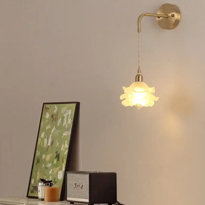 A warm-toned decorbites led glass wall lamp with petal design and brass mount for modern bedroom lighting