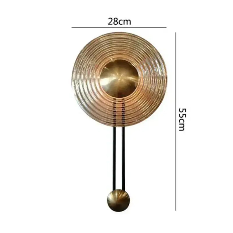 Decorbites led glass wall lamp features a brass-colored concentric circle clock design with black pendulum and gold accents